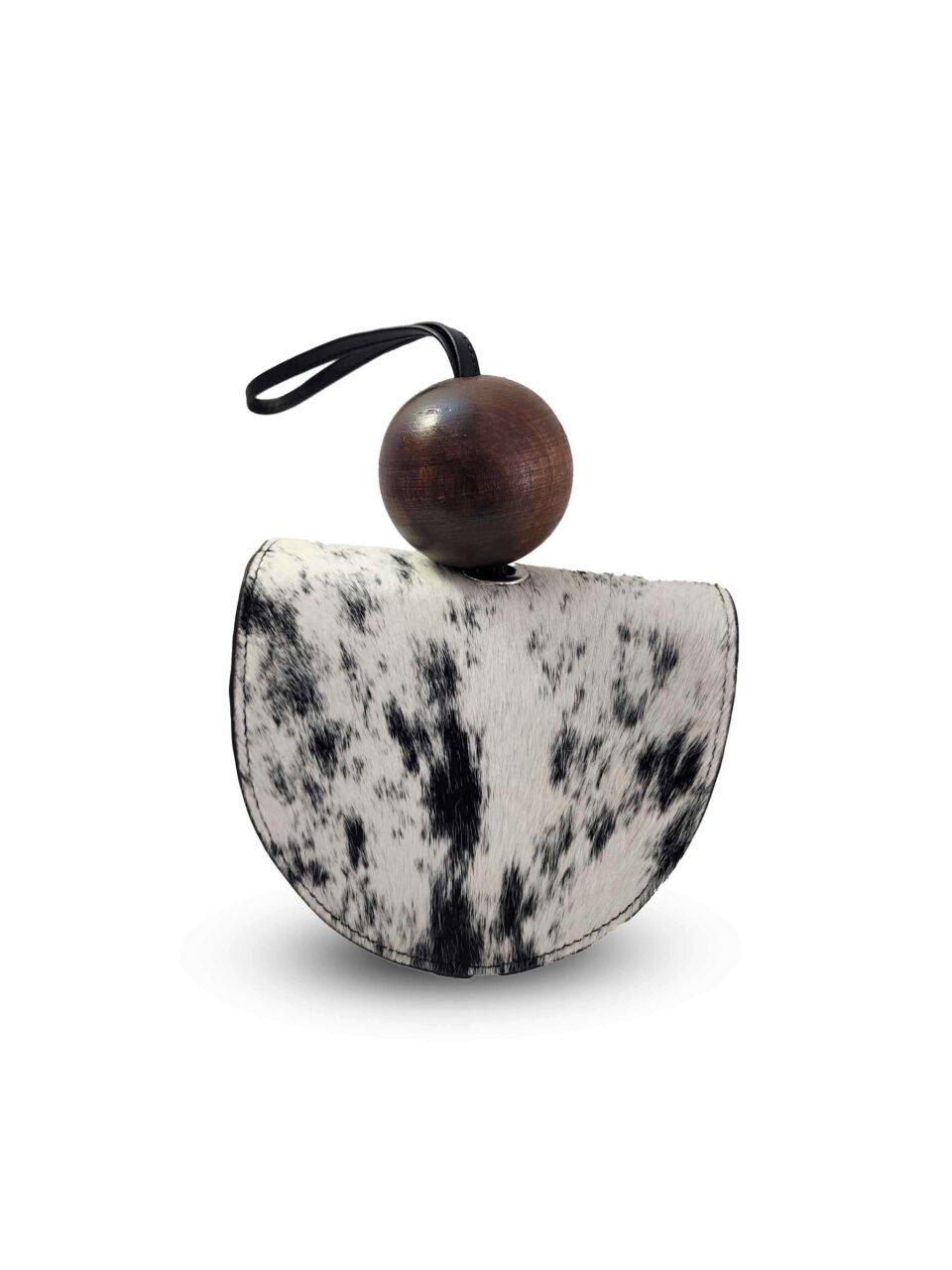 Clutch Wayra artesanal hecho en Perú con cuero de pelo natural blanco y negro, diseño circular estructurado y esfera de madera sostenible.